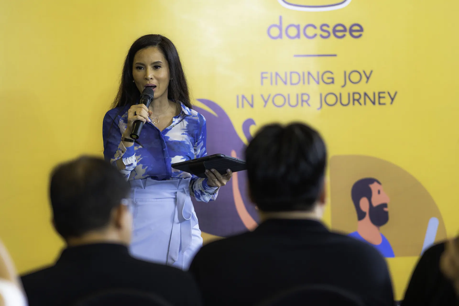 Daphne Iking hosting a large professional event on stage.