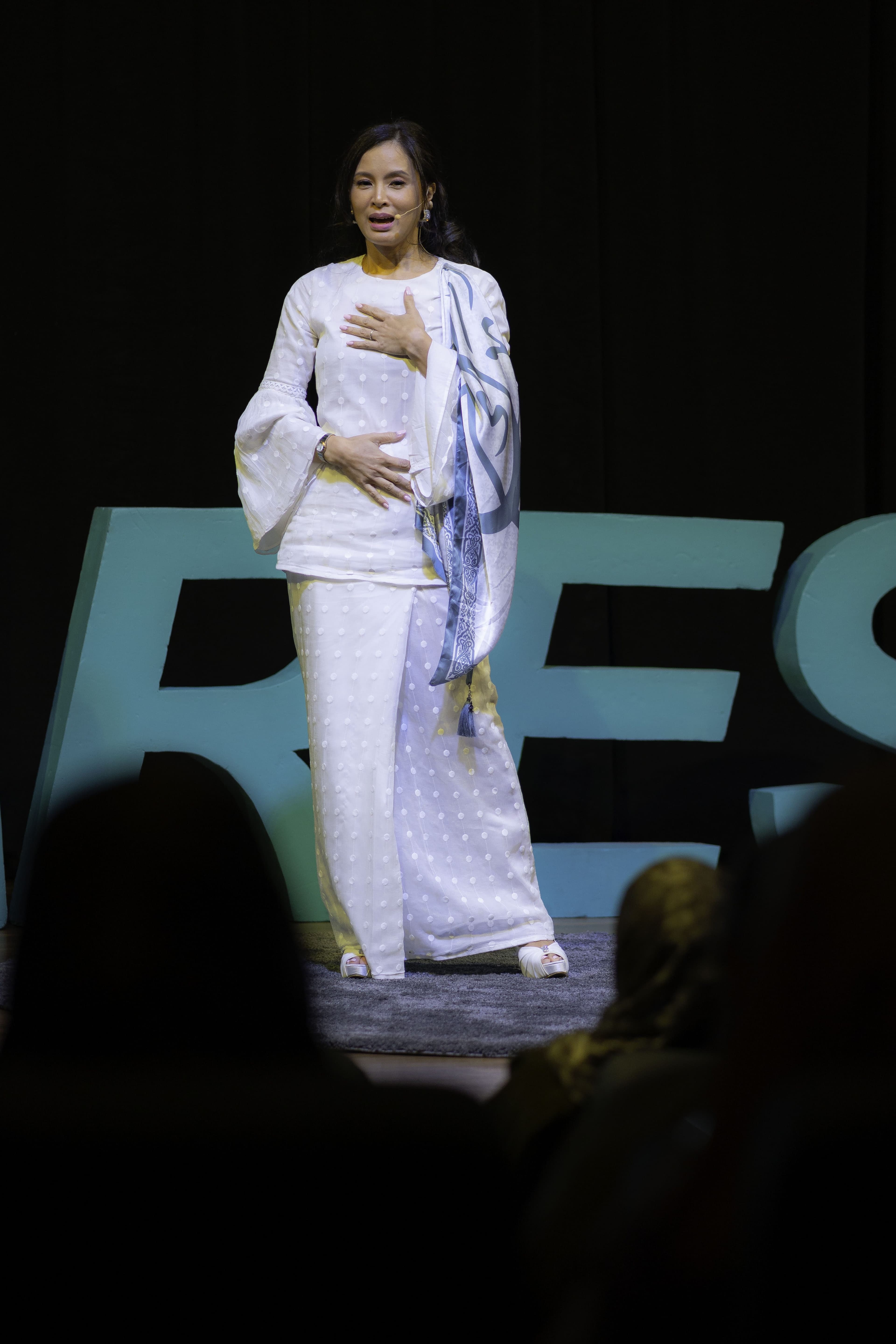 Daphne Iking speaking on stage at a Deft Talks event